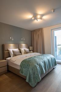 a bedroom with a large bed and a large window at The Sailor, full sea view, use of hotel swimming pool and sauna in Cadzand