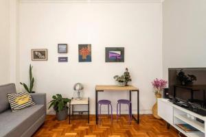 Sala de estar con mesa y 2 taburetes púrpuras en Hotel Mama! Copacabana (Posto1 -Leme) en Río de Janeiro