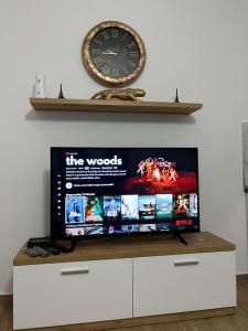 a tv on a dresser with a clock on the wall at Apartment Elbasan city center 2 in Elbasan