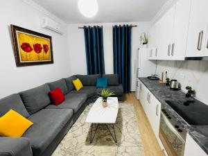 a living room with a gray couch with colorful pillows at Apartment Elbasan city center 2 in Elbasan