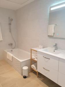 ein weißes Badezimmer mit einer Badewanne und einem Waschbecken in der Unterkunft Casa cariño in Alicante