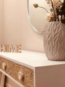 a vase sitting on a table with a mirror at Precioso apartamento en Los Castros in Santander