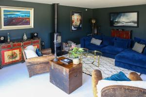 a living room with blue couches and a table at Hurstpierpoint 3 bedroom House with Hot-Tub & Garden in West Sussex in Hurstpierpoint