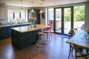 a kitchen with a large island with a wooden counter top at Hurstpierpoint 3 bedroom House with Hot-Tub & Garden in West Sussex in Hurstpierpoint