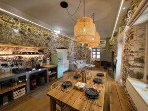 a large room with a wooden table and a kitchen at The Stone House in Avdhoulianá