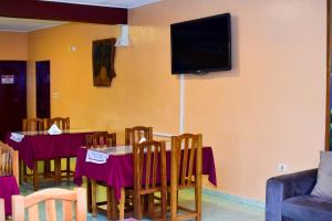 a dining room with a table and a tv on the wall at Palmas Park Hotel y Restaurant in Obligado