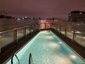 - une piscine sur le toit d'un bâtiment la nuit dans l'établissement Moderno departamento Miraflores 360, à Lima
