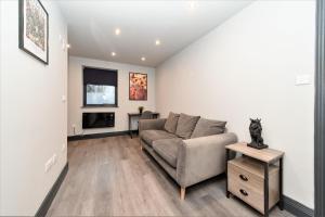 a living room with a couch and a tv at King Size Bed Super Morden One Bedroom Flat next to Seafront in Brighton & Hove