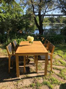 una mesa de madera con 2 sillas y un jarrón de flores en La Maison Jaune D'Eastman, en Eastman