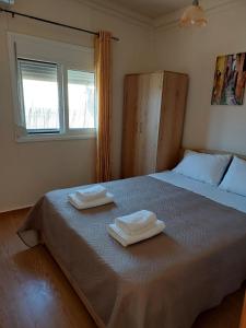 a bedroom with a bed with two towels on it at Kima House in Kalamaki Heraklion