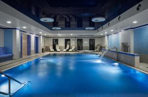 a swimming pool in a hotel room with blue lighting at Grandhotel Nabokov in Mariánské Lázně