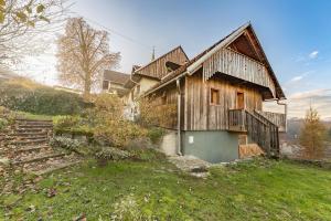 una vieja casa de madera en una colina con unas escaleras en Svisla, en Kranj