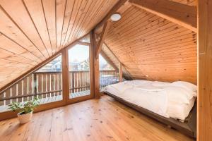 a bed in a room with a wooden ceiling at Svisla in Kranj