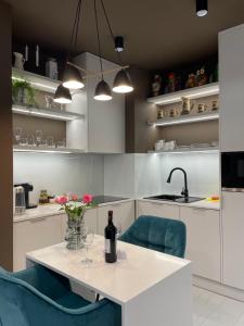 a kitchen with a table and two blue chairs at Apartment z kominkiem w sercu Wrocławia in Wrocław