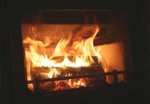 a fire in a brick oven with flames at Casa d'Avó Serra da Estrela in Seia