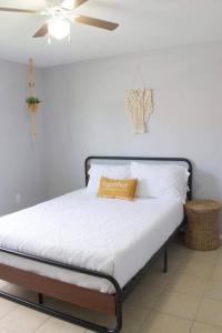 a bed in a room with a ceiling fan at Casa Mezquite. In Downtown Brownsville in Brownsville
