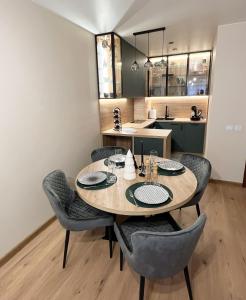 a dining room table with chairs and a kitchen at The Green apartment in Borovets
