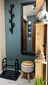 a bathroom with a mirror and a bench and a stool at The Green apartment in Borovets