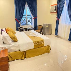 um quarto com uma cama grande e cortinas azuis em احلام الشاطئ للشقق المفروشة em Ar Ruʼays