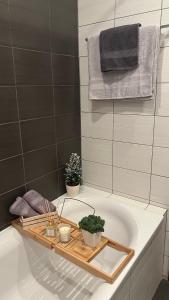bagno con vasca, piante e asciugamani. di The Green apartment a Borovets