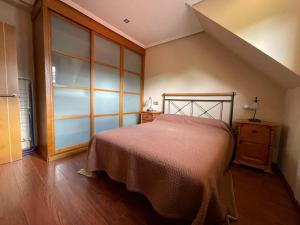 a bedroom with a bed and a wooden floor at Apartamento Centro de Llanes in Llanes