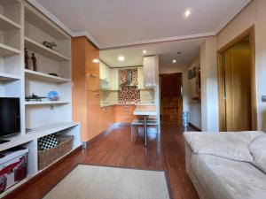 a living room with a bed and a dining room at Apartamento Centro de Llanes in Llanes