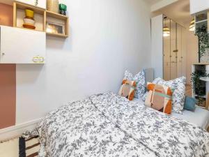 ein Schlafzimmer mit einem großen Bett mit Kissen in der Unterkunft Studio de charme à 2 pas de Paris in Malakoff