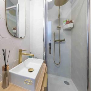 ein weißes Bad mit einem Waschbecken und einer Dusche in der Unterkunft Studio de charme à 2 pas de Paris in Malakoff