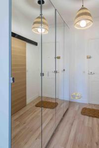 a bathroom with a glass shower with two lights at Studio de charme à 2 pas de Paris in Malakoff