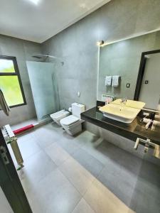 La salle de bains est pourvue d'un lavabo, de toilettes et d'un miroir. dans l'établissement Casa en Barrio privado Luján, à Luján de Cuyo