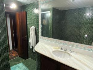 a bathroom with a sink and a mirror at Praia dos Ossos Guest House - Búzios com pé na areia in Búzios