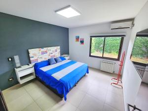 1 dormitorio con 1 cama con edredón azul en Casa en Barrio privado Luján en Luján de Cuyo
