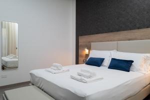 ein Schlafzimmer mit einem großen weißen Bett mit blauen Kissen in der Unterkunft MyHouse Pompei in Pompei