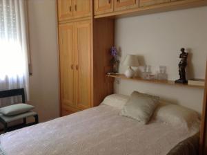 a bedroom with a bed and a cabinet and a chair at Feliz Costa Brava Apartamento in Portbou