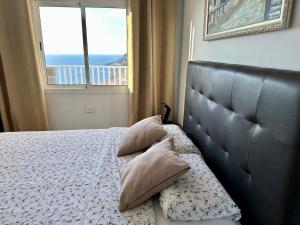 a bedroom with a bed with a view of the ocean at Perla de Amadores in Amadores