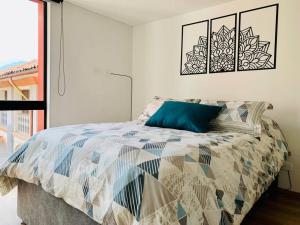 Un dormitorio con una cama con una almohada azul. en Amazing loft in La Candelaria, en Bogotá