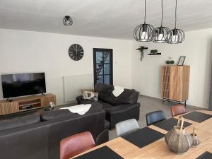 a living room with a couch and a tv and a table at THE 77 work or holiday new home in Houthem