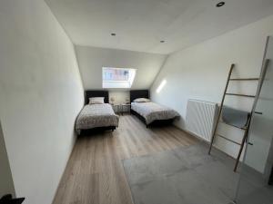 a attic room with two beds and a ladder at THE 77 work or holiday new home in Houthem