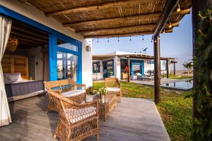 eine Terrasse mit Korbstühlen, einem Tisch und einem Bett in der Unterkunft Topara Hotel Boutique in San Vicente de Cañete