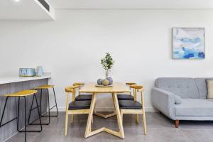 雪梨的住宿－Modern 1 Bed Apt OP MHS，一间带桌子和沙发的用餐室