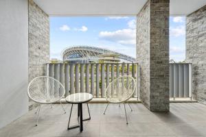 a balcony with two chairs and a stadium at Modern 1 Bed Apt OP MHS in Sydney