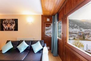 a living room with a couch and a large window at S Valle de incles- Grandvalira free parking in Canillo