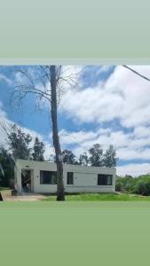 a white building with a tree in front of it at Casa muy luminosa , 2 d in José Ignacio