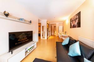 a living room with a black couch and a flat screen tv at S Valle de incles- Grandvalira free parking in Canillo