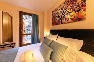 a bedroom with a bed with a painting on the wall at S Valle de incles- Grandvalira free parking in Canillo