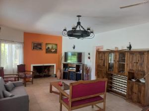 a living room with a couch and a tv at Calma Vistalba in Ciudad Lujan de Cuyo