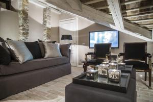 a living room with a couch and a tv at Seven Historical Suites in Trieste