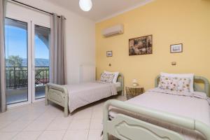Villa Sunshine في مدينة زاكينثوس: غرفة نوم بسريرين وشرفة