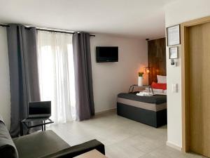 uma sala com um quarto com uma cama e um sofá em Life ATMOsphäre Apartment Lahr-Schwarzwald em Lahr