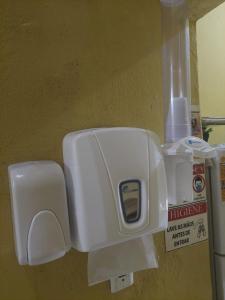a white toilet paper dispenser on a wall at Pousada Aconchego de Mãe in Fortaleza